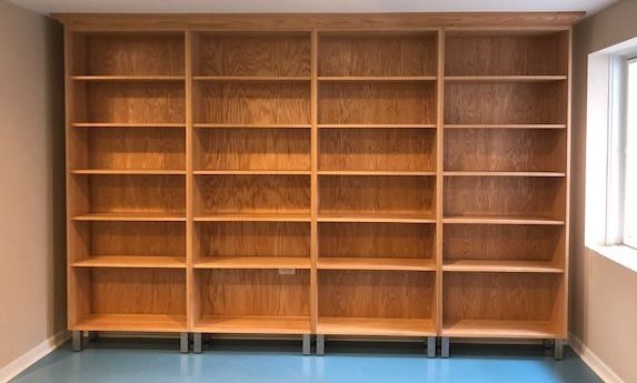 Tall hardwood bookcase with natural finish and metal legs